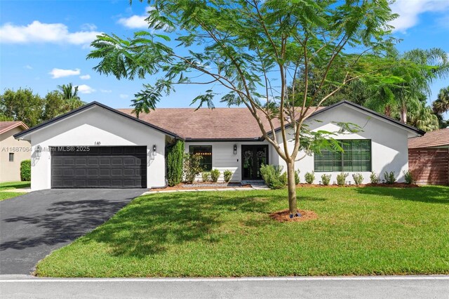 ranch-style home with a garage and a yard