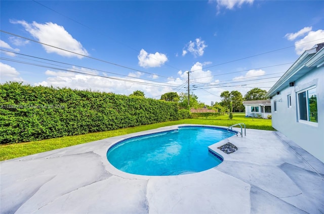 view of pool with a lawn and a patio