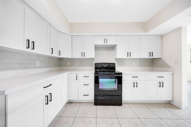 kitchen with black range with electric stovetop, white cabinets, and light tile patterned floors