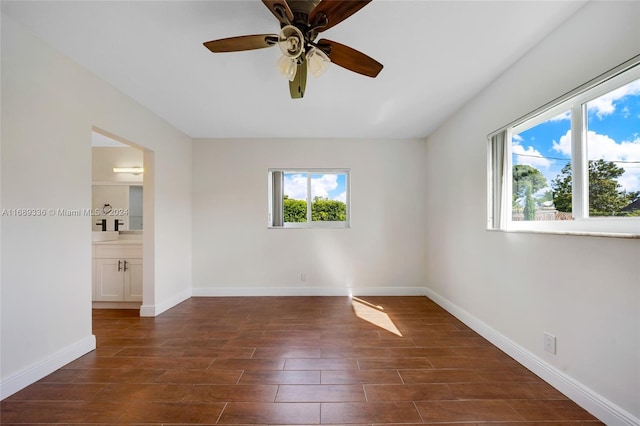 empty room with ceiling fan and dark hardwood / wood-style floors