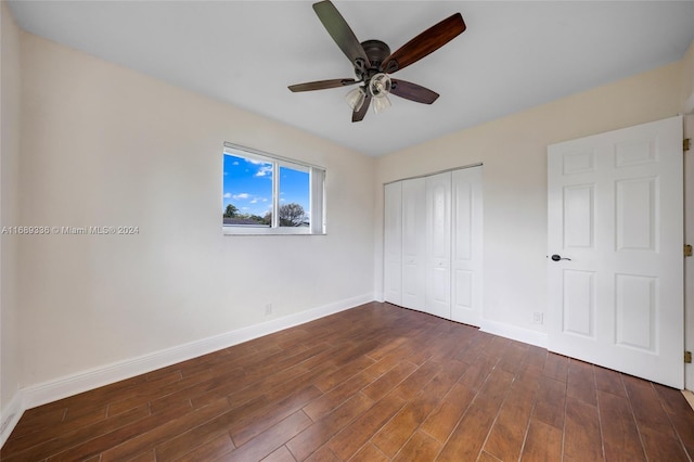 unfurnished bedroom featuring ceiling fan, a closet, and dark wood-type flooring