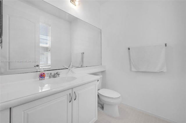 bathroom featuring tile patterned flooring, vanity, and toilet