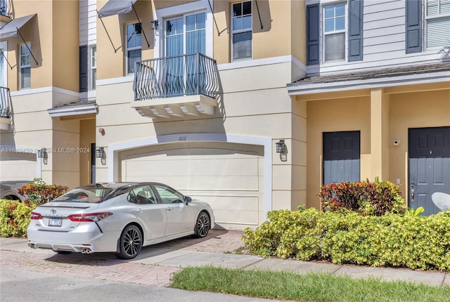 entrance to property with a garage and a balcony