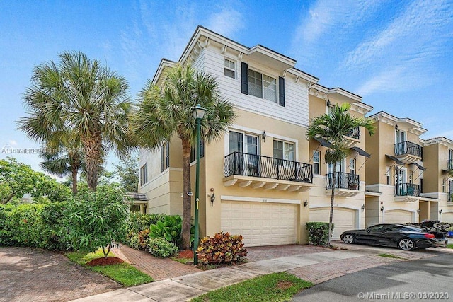 townhome / multi-family property featuring a balcony and a garage