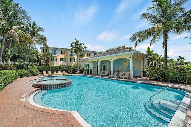 view of pool with a community hot tub and a patio area