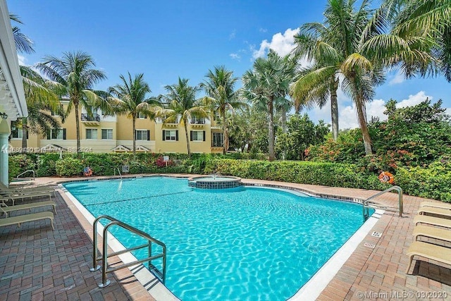 view of pool featuring a hot tub and a patio