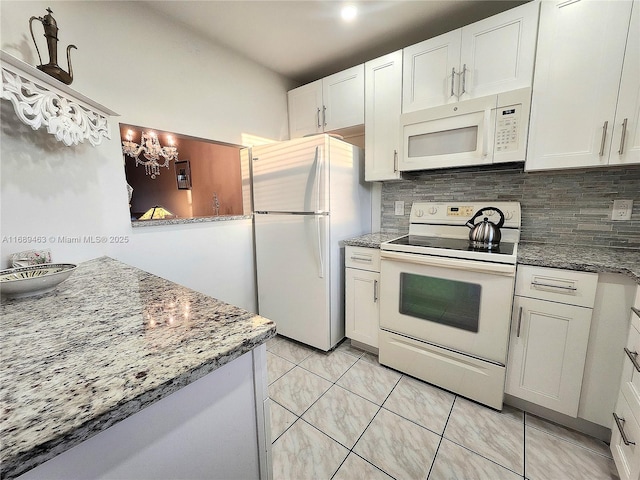 kitchen with dark stone countertops, white cabinets, a notable chandelier, white appliances, and backsplash