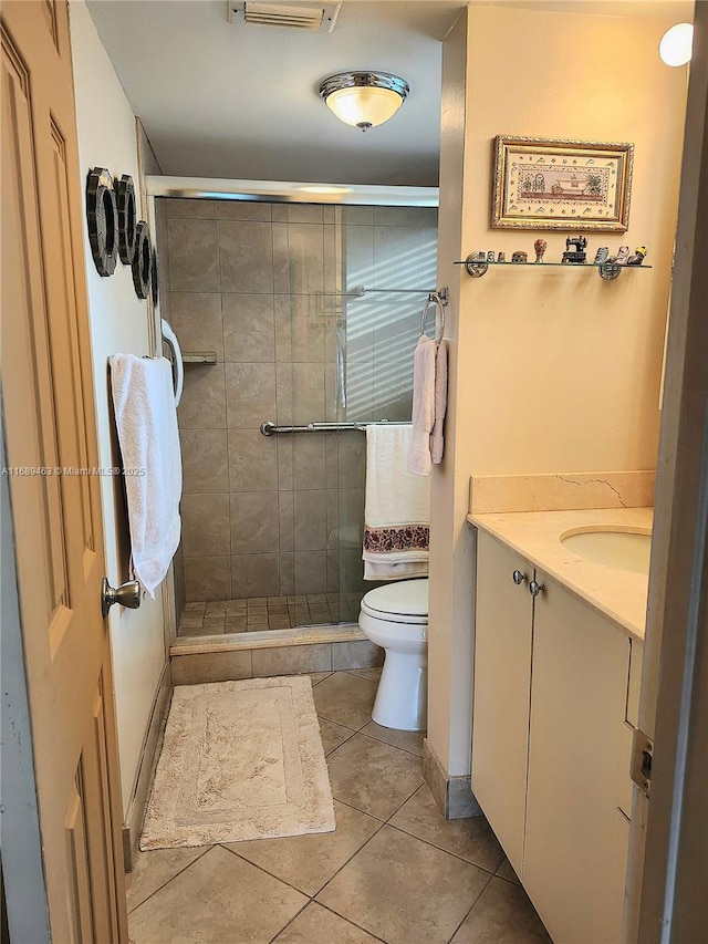 bathroom featuring vanity, an enclosed shower, tile patterned flooring, and toilet