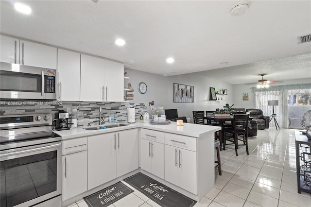 kitchen featuring kitchen peninsula, ceiling fan, white cabinetry, and appliances with stainless steel finishes