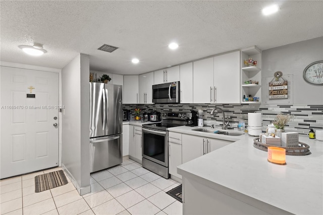 kitchen featuring white cabinets, decorative backsplash, stainless steel appliances, and sink