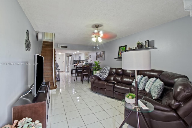 tiled living room featuring a textured ceiling and ceiling fan