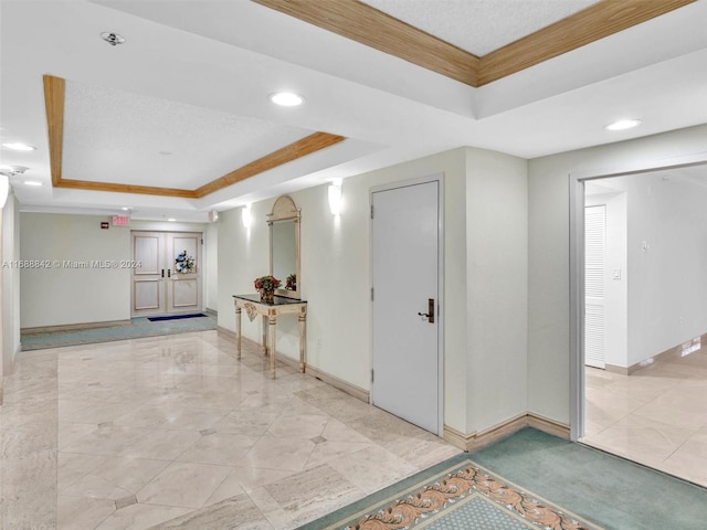 interior space featuring a raised ceiling and crown molding