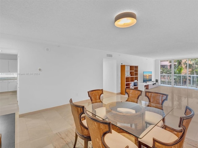 dining area featuring a textured ceiling and light tile patterned flooring