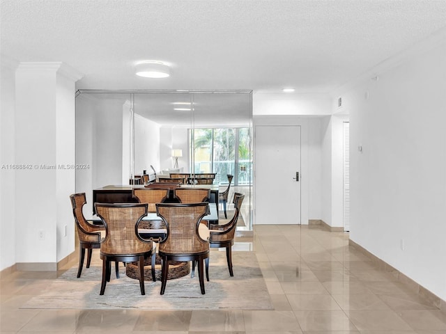 tiled dining room with a textured ceiling and crown molding