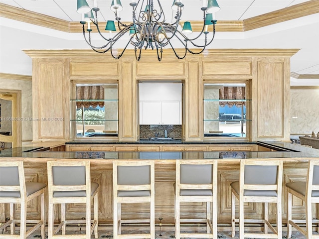 kitchen featuring decorative backsplash, light brown cabinets, and a notable chandelier