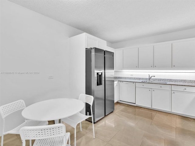 kitchen with a textured ceiling, sink, dishwasher, white cabinets, and stainless steel fridge with ice dispenser