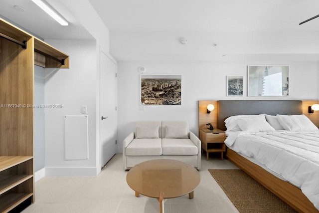 bedroom with a barn door and light tile patterned floors