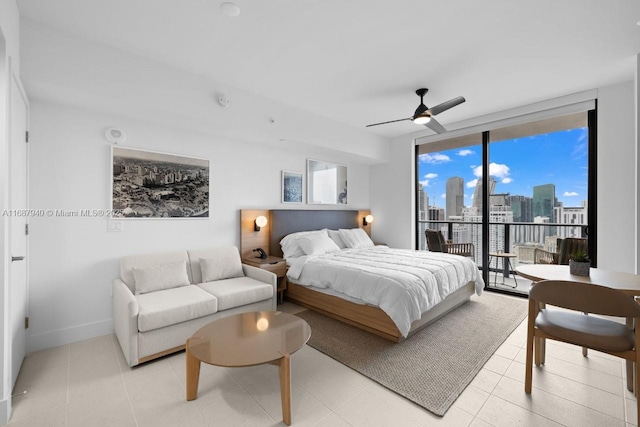 bedroom with access to outside, expansive windows, and ceiling fan