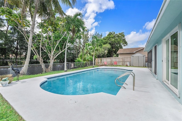 view of swimming pool featuring a patio and a shed