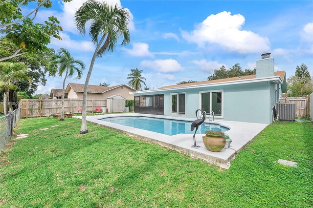 view of swimming pool with a lawn, a sunroom, and a patio area