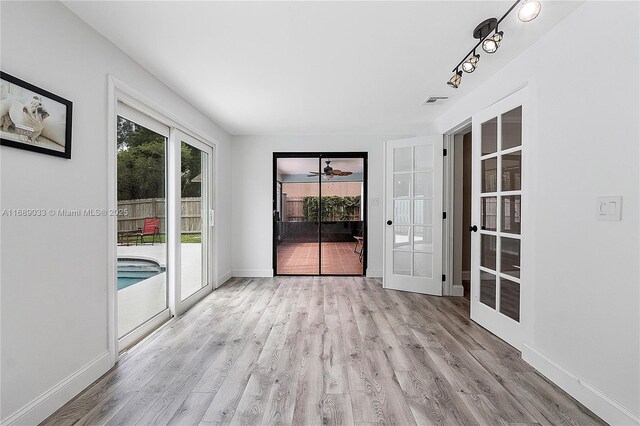 empty room featuring french doors and light wood-type flooring