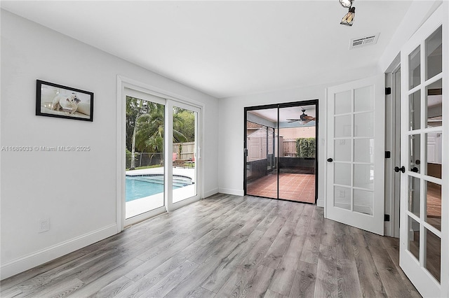 empty room featuring ceiling fan, light hardwood / wood-style flooring, and french doors