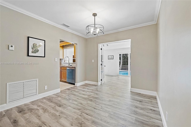 spare room with sink, an inviting chandelier, light hardwood / wood-style floors, and ornamental molding