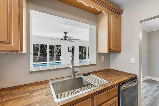 kitchen with dishwasher, sink, ceiling fan, ornamental molding, and light hardwood / wood-style floors