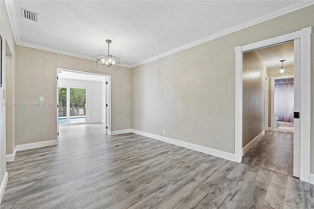 spare room with ornamental molding, light hardwood / wood-style flooring, and a notable chandelier