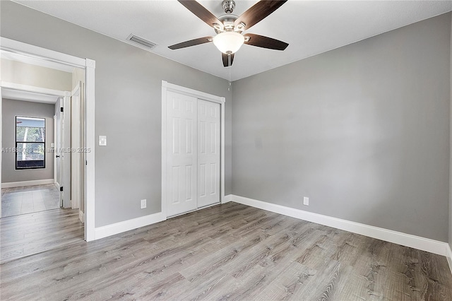 unfurnished bedroom featuring ceiling fan, a closet, and light hardwood / wood-style flooring