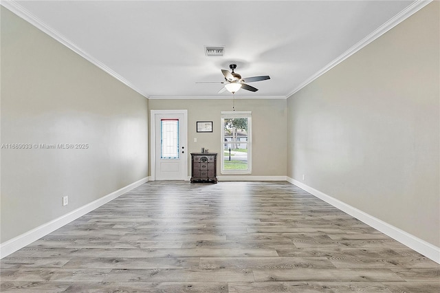 empty room featuring ceiling fan, crown molding, and light hardwood / wood-style flooring