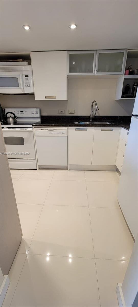 kitchen with white cabinetry, light tile patterned flooring, white appliances, and sink