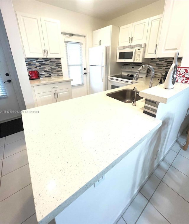 kitchen with white cabinets, white appliances, sink, and decorative backsplash