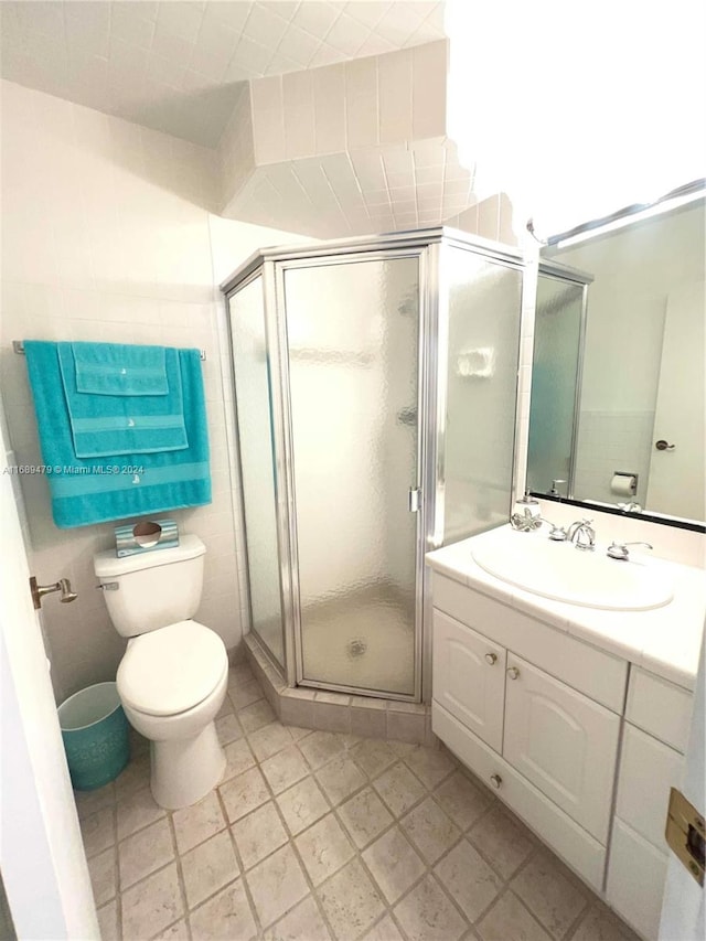 bathroom with a shower with door, vanity, and toilet