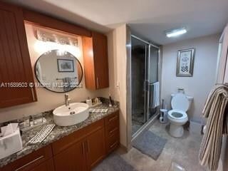 bathroom with an enclosed shower, vanity, and toilet