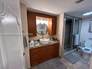 bathroom with walk in shower, vanity, and toilet