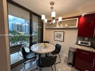 tiled dining room featuring a chandelier