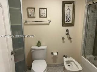 bathroom with toilet, a bidet, and enclosed tub / shower combo