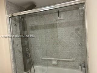 bathroom with shower / bath combination with glass door