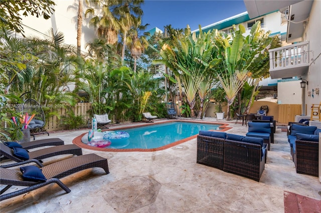 pool at dusk featuring an outdoor living space and a patio area