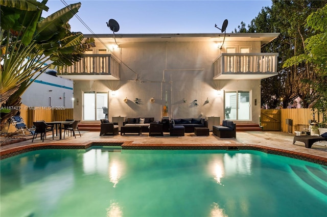 back of house featuring a fenced in pool, an outdoor hangout area, a patio, and a balcony