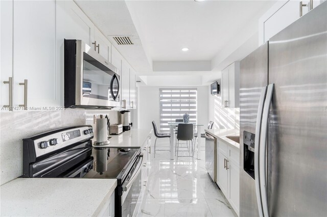 kitchen with white cabinets and appliances with stainless steel finishes