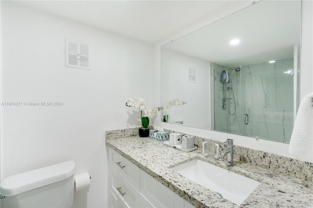 bathroom featuring an enclosed shower, vanity, and toilet