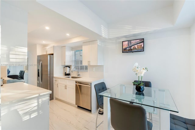 kitchen featuring decorative backsplash, sink, a raised ceiling, white cabinetry, and appliances with stainless steel finishes