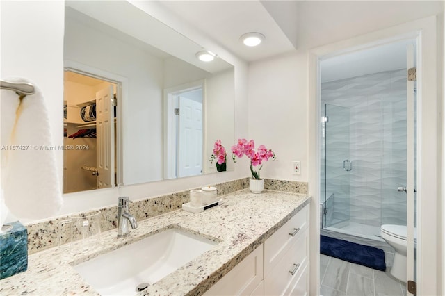 bathroom with toilet, vanity, and an enclosed shower