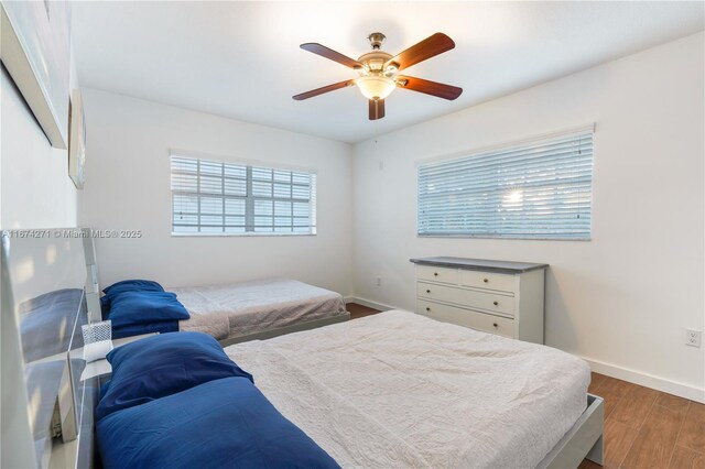 bedroom with dark hardwood / wood-style flooring and ceiling fan