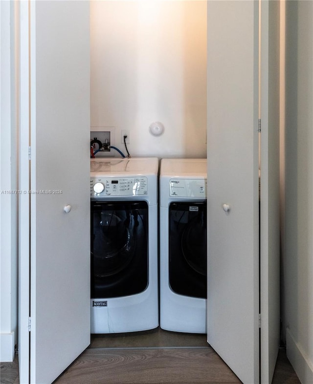 laundry area with dark wood-type flooring and washing machine and clothes dryer