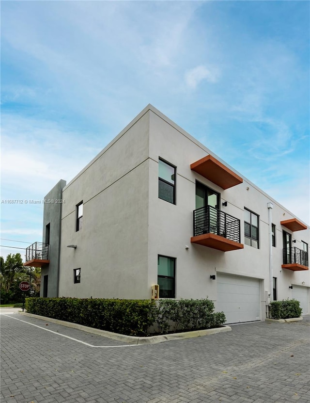 view of home's exterior featuring a garage and a balcony