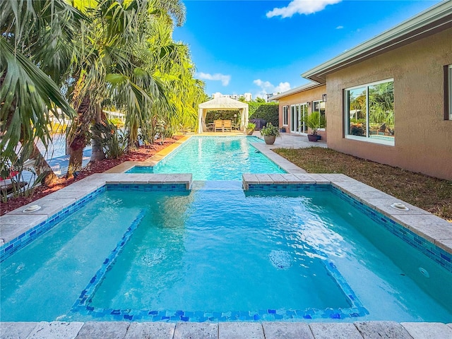 view of pool featuring a patio area, a gazebo, and an in ground hot tub