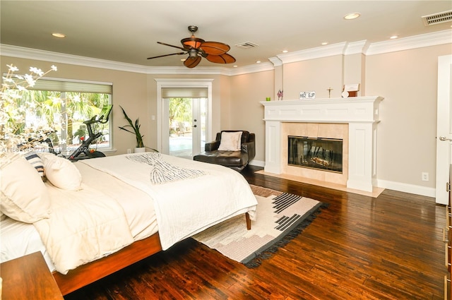 bedroom featuring dark wood-type flooring, ceiling fan, a tile fireplace, and access to outside